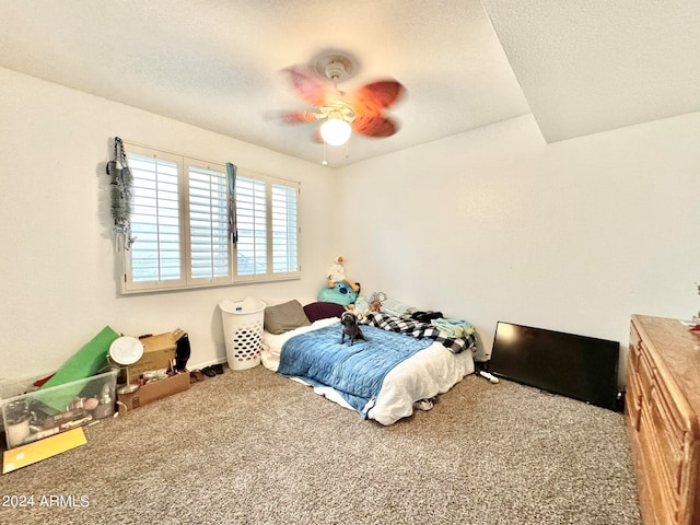 bedroom featuring ceiling fan, carpet floors, and a textured ceiling