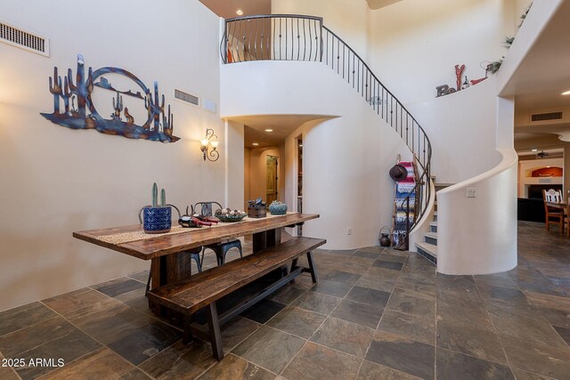 8606 E Arroyo Seco Rd, Scottsdale, AZ 85266 - dining space featuring stone tile floors, stairway, and a high ceiling
