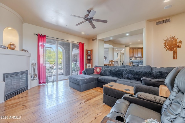 8606 E Arroyo Seco Rd, Scottsdale, AZ 85266 - living room with a ceiling fan, light wood-style flooring, a glass covered fireplace, and recessed lighting