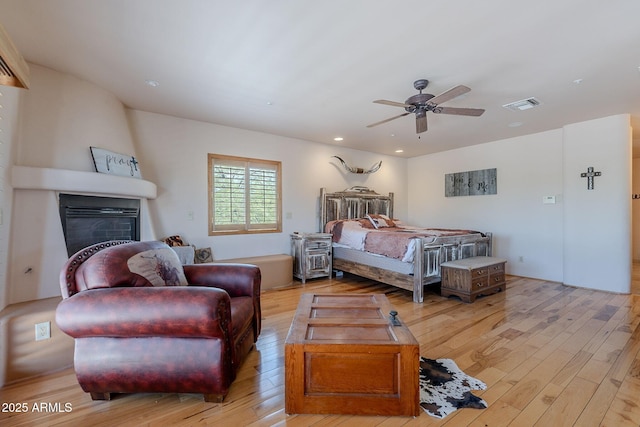 8606 E Arroyo Seco Rd, Scottsdale, AZ 85266 - bedroom featuring a fireplace, light wood-type flooring, recessed lighting, and a ceiling fan