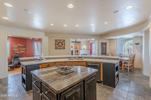 8606 E Arroyo Seco Rd, Scottsdale, AZ 85266 - kitchen with a spacious island, a sink, a ceiling fan, stone tile floors, and open shelves