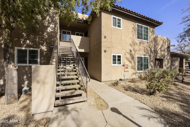 exterior space with stairway and stucco siding