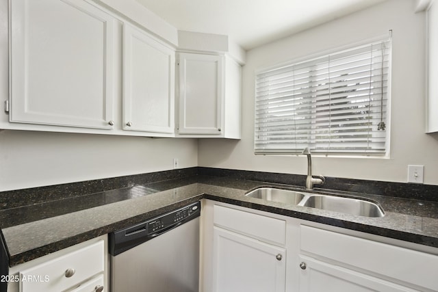 kitchen featuring dark stone counters, white cabinetry, a sink, and stainless steel dishwasher