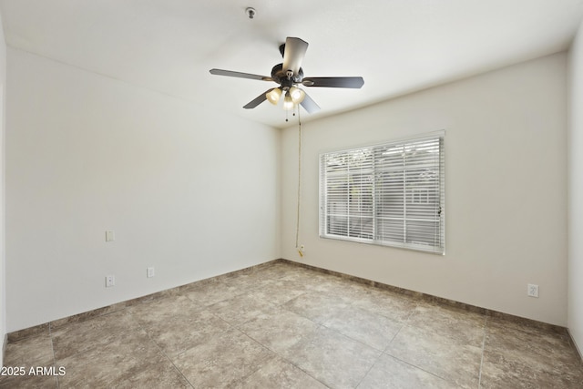 unfurnished room featuring a ceiling fan and baseboards