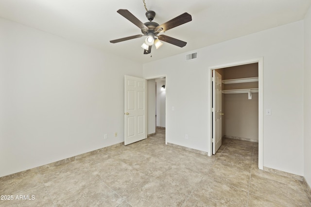 unfurnished bedroom featuring a spacious closet, a closet, visible vents, and a ceiling fan