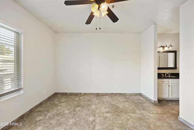 empty room featuring baseboards and a ceiling fan