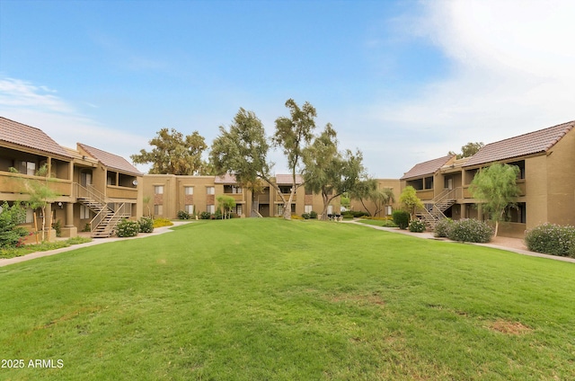 view of community featuring a lawn and stairs