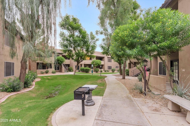 view of property's community with a yard and stairway