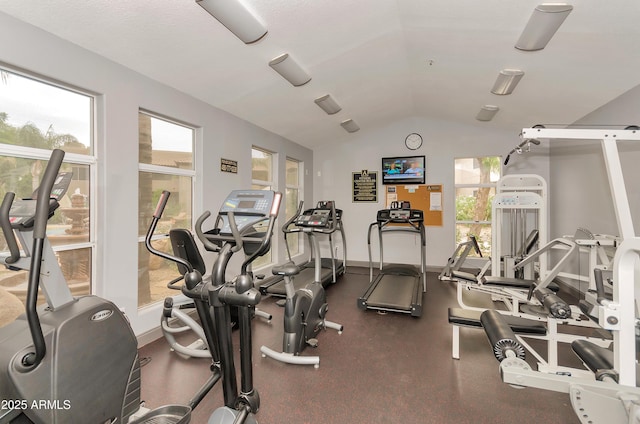 workout area featuring vaulted ceiling and baseboards