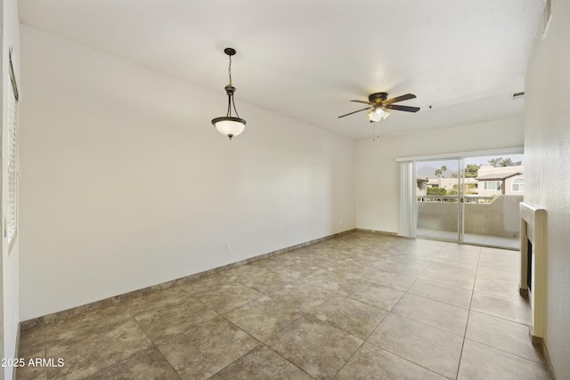 empty room featuring tile patterned flooring, visible vents, ceiling fan, and baseboards