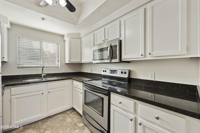 kitchen with stainless steel appliances, white cabinetry, a sink, and a ceiling fan