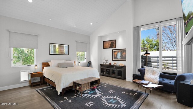 bedroom with wood-type flooring, wooden ceiling, multiple windows, and high vaulted ceiling