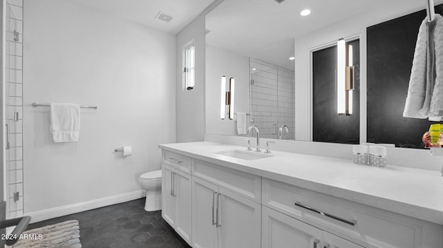 bathroom with vanity, a shower with shower door, toilet, and tile patterned flooring