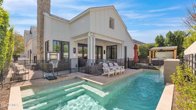 rear view of house featuring pool water feature, a patio area, a fenced in pool, and an outdoor hangout area