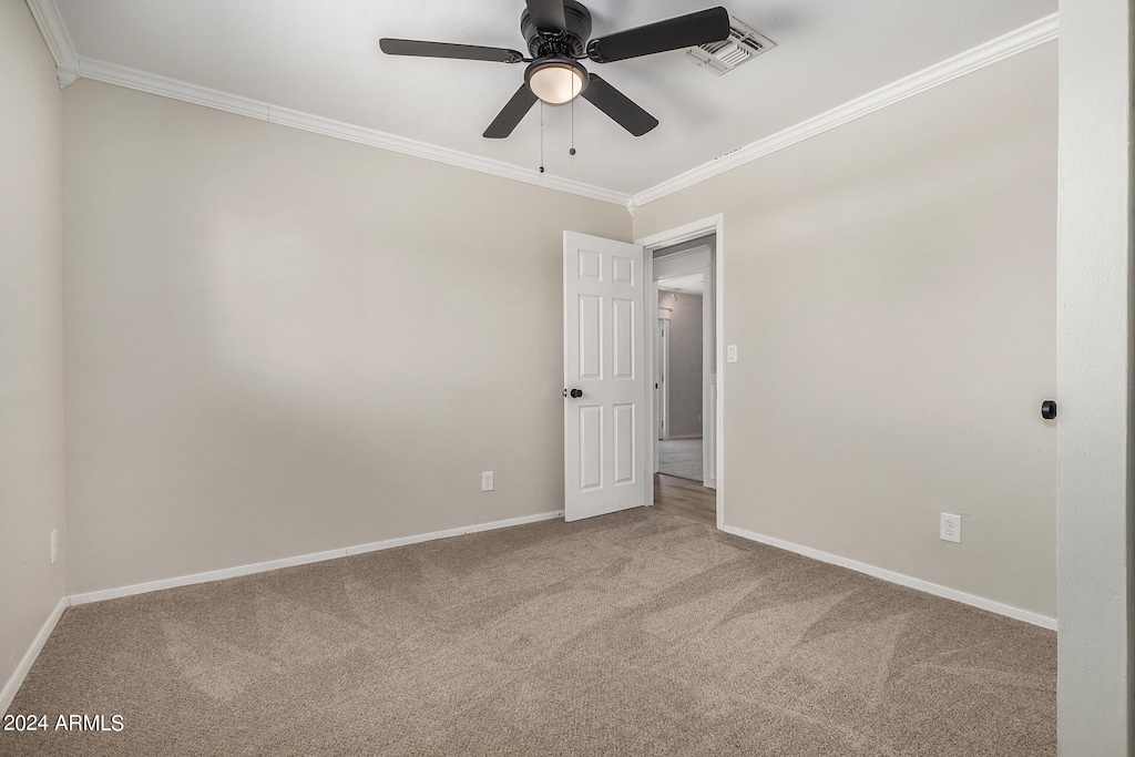 spare room featuring ornamental molding, light carpet, and ceiling fan