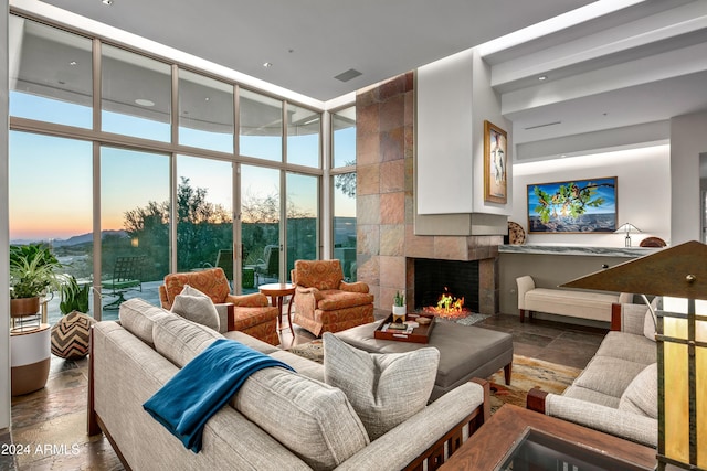 living room with a tiled fireplace and expansive windows