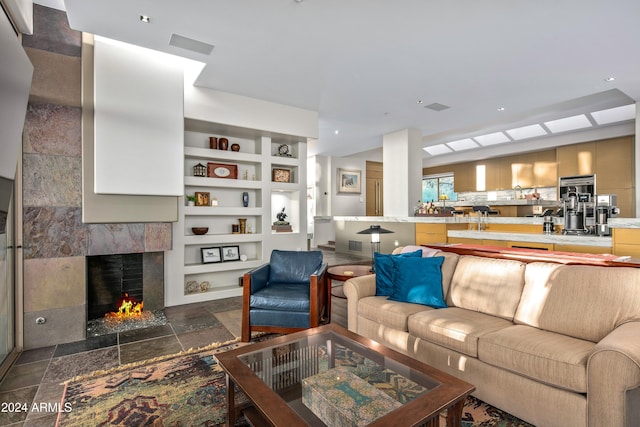 living room featuring a high end fireplace and built in shelves