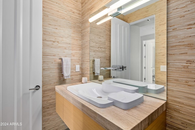 bathroom with vanity and wood walls