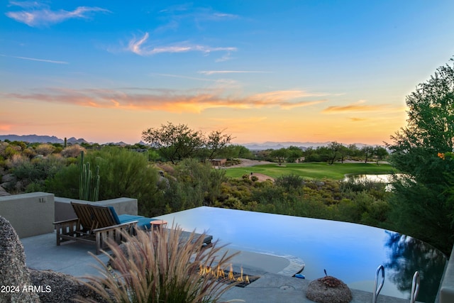 pool at dusk featuring a patio