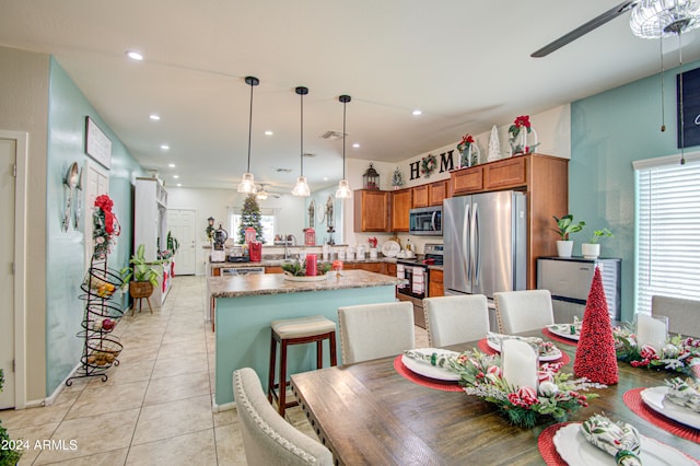 tiled dining room with ceiling fan and sink