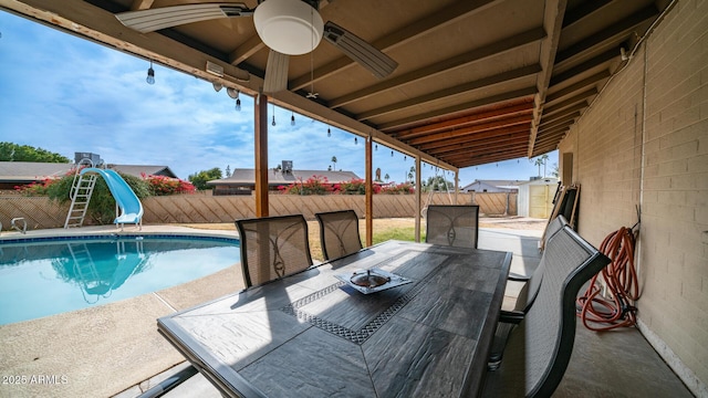 exterior space with a water slide, a storage unit, ceiling fan, and a patio area