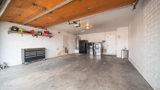 garage with a garage door opener, gas water heater, and independent washer and dryer