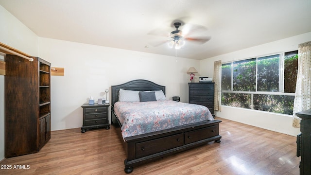 bedroom featuring multiple windows, ceiling fan, and light wood-type flooring