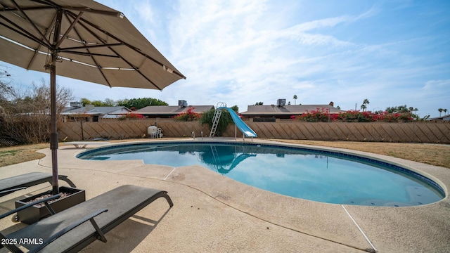 view of swimming pool with a water slide and a patio