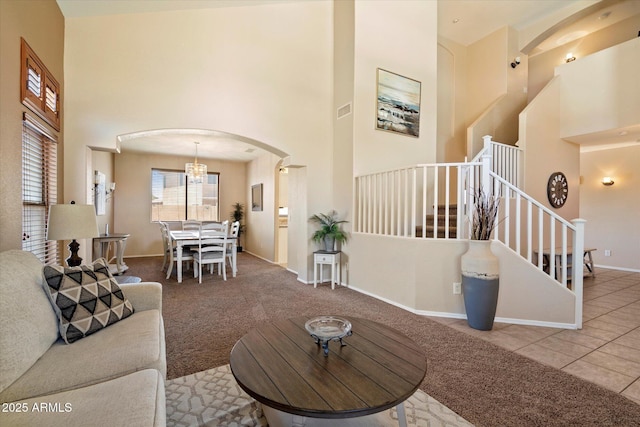 25818 N 68th Ave, Peoria, AZ 85383 - carpeted living area featuring a high ceiling, arched walkways, stairs, and a chandelier
