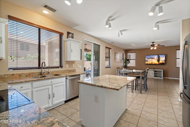 25818 N 68th Ave, Peoria, AZ 85383 - kitchen with stainless steel appliances, a center island, light tile patterned flooring, ceiling fan, and white cabinetry