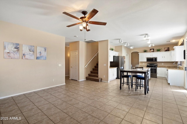 25818 N 68th Ave, Peoria, AZ 85383 - kitchen featuring stainless steel appliances, a ceiling fan, light tile patterned floors, arched walkways, and light countertops
