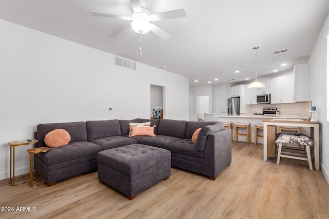 living room featuring ceiling fan and light hardwood / wood-style floors