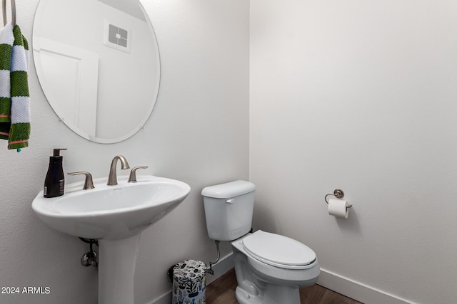 bathroom featuring wood-type flooring and toilet