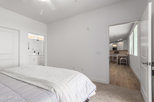 carpeted bedroom with ceiling fan and ensuite bath