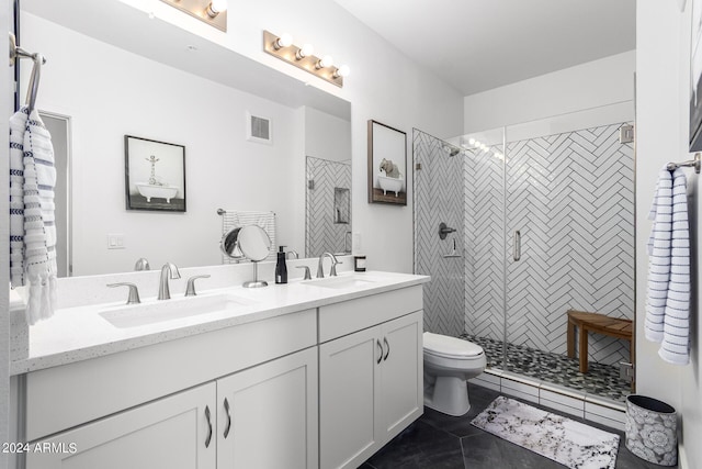 bathroom with vanity, tile patterned floors, toilet, and tiled shower