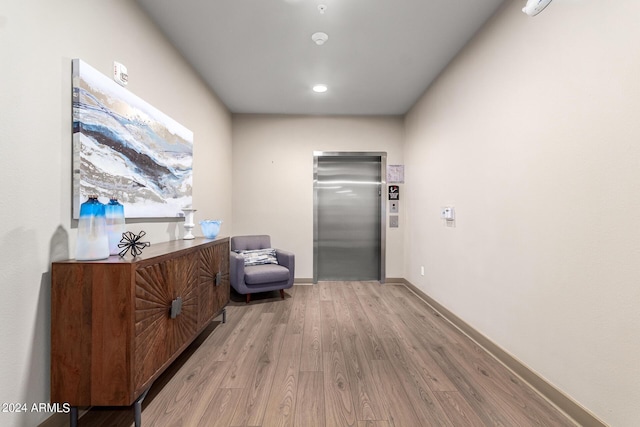 hallway featuring elevator and light hardwood / wood-style floors