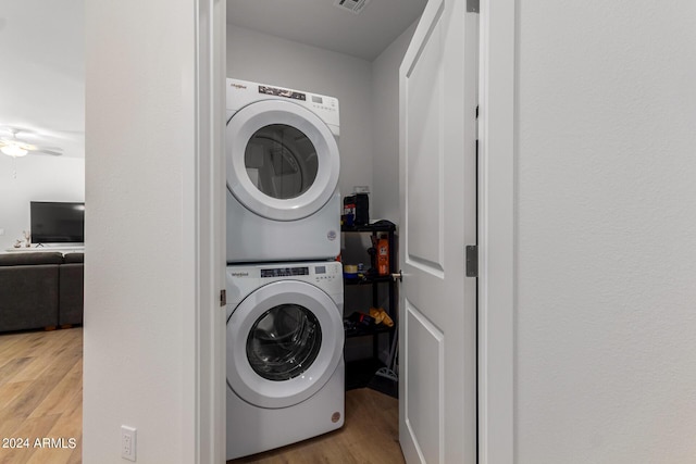 laundry area with stacked washer and dryer, wood-type flooring, and ceiling fan