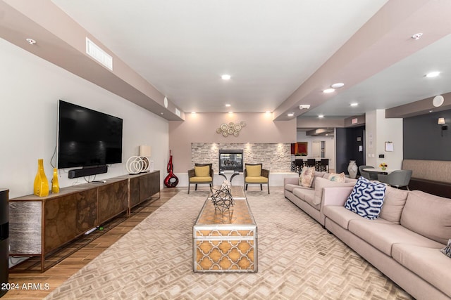 living room featuring hardwood / wood-style flooring and a stone fireplace