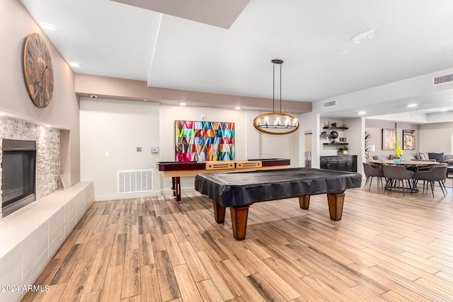 game room featuring billiards, a tiled fireplace, and light hardwood / wood-style flooring