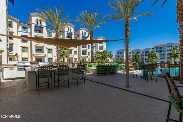 view of patio with a grill, exterior bar, and an outdoor kitchen