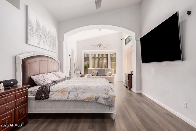 bedroom featuring lofted ceiling, a ceiling fan, dark wood finished floors, arched walkways, and baseboards