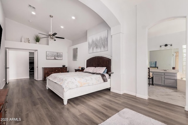 bedroom featuring visible vents, a sink, wood finished floors, recessed lighting, and arched walkways