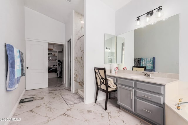 bathroom featuring marble finish floor, a walk in shower, vanity, and a garden tub