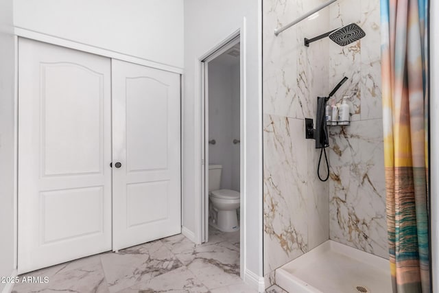 bathroom with toilet, marble finish floor, and a marble finish shower