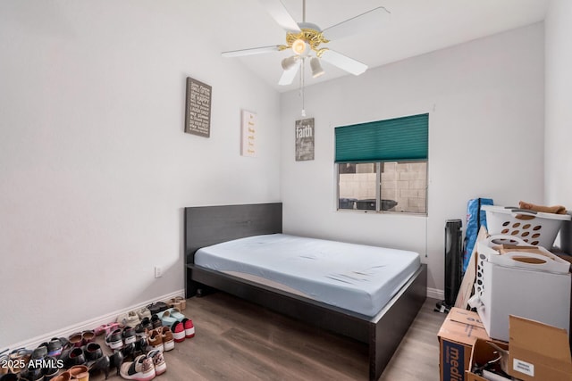 bedroom featuring baseboards, wood finished floors, and a ceiling fan