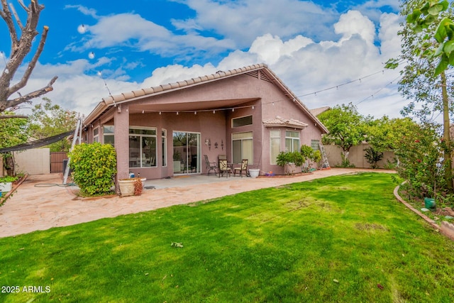 rear view of house featuring a patio area, a yard, stucco siding, and fence