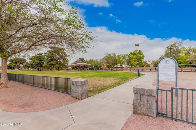 surrounding community featuring a gate, a lawn, and fence