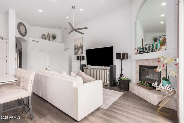 living area featuring visible vents, ceiling fan, recessed lighting, a tile fireplace, and wood finished floors