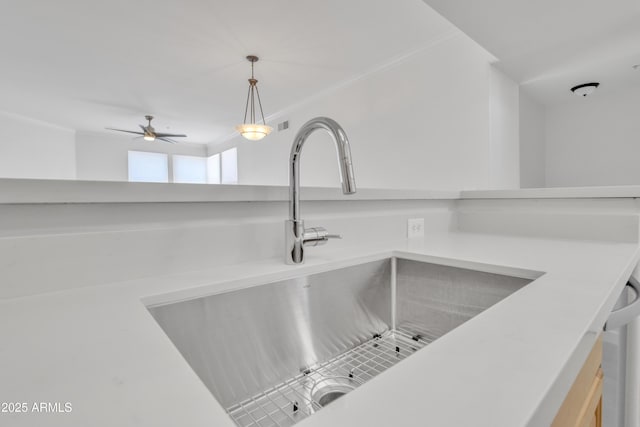 interior details featuring crown molding, sink, and decorative light fixtures