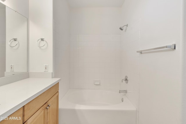 bathroom featuring tiled shower / bath combo and vanity